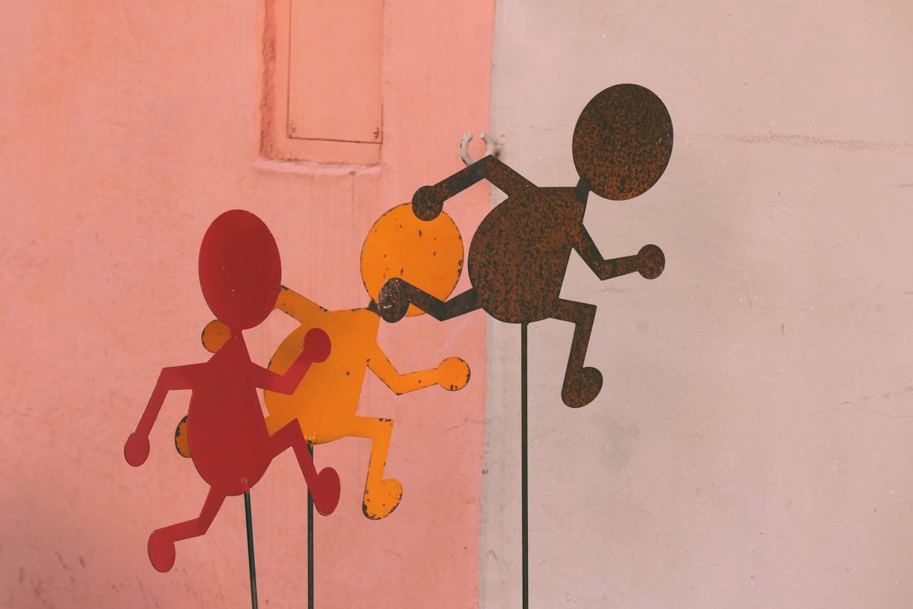 Artistic metal cutouts in red and orange against a pastel wall create a vibrant outdoor scene in Regensburg.